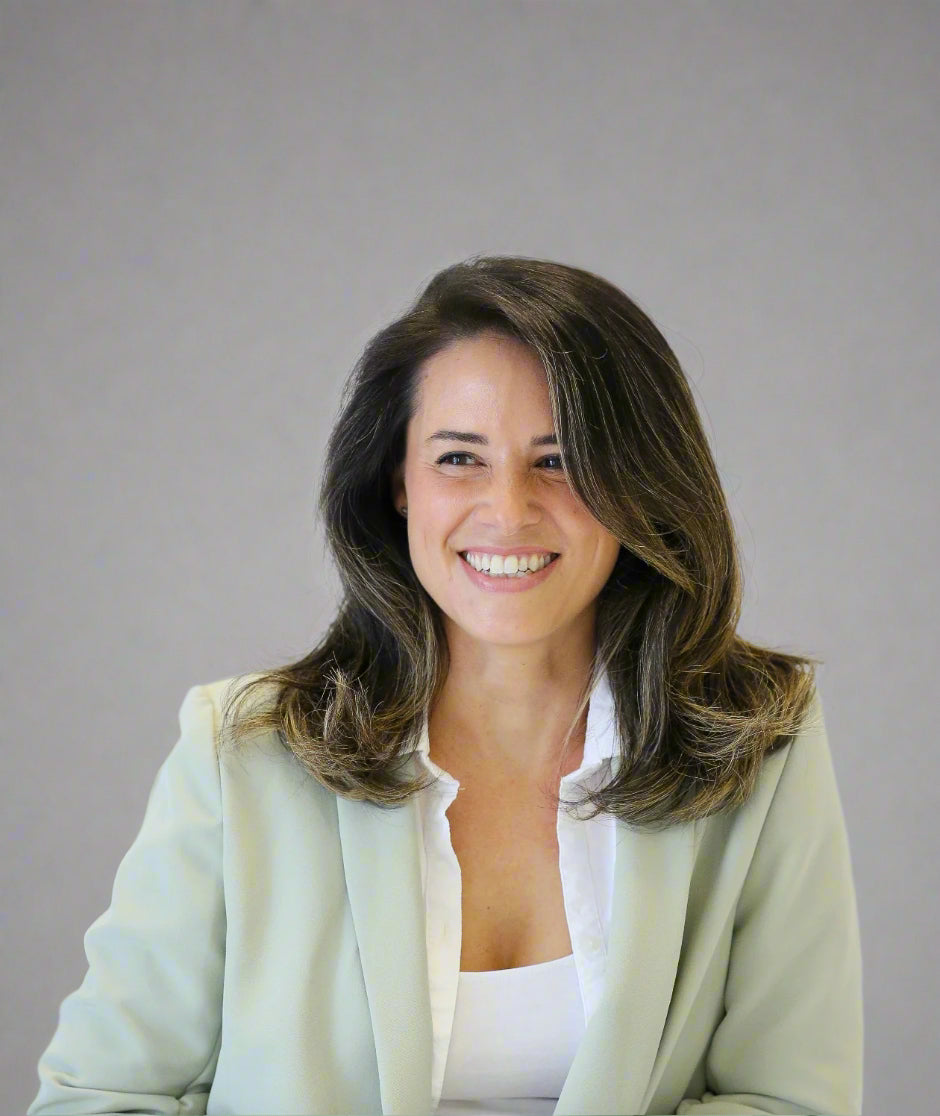 Sarah wearing a light green blazer over a white shirt against a plain background