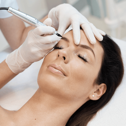 Woman receiving a cosmetic procedure on her face with gloves and equipment.